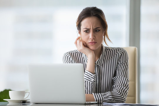 Woman looking at her computer confused.