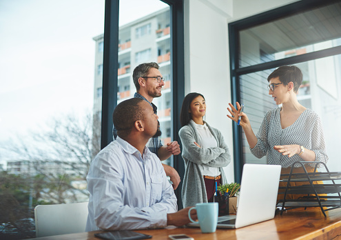 Group of four employees having a meeting.